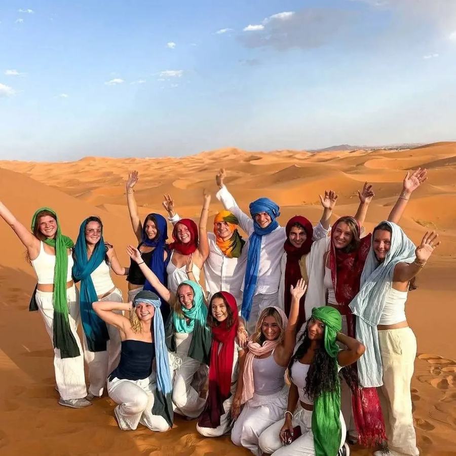 Grupo de viajeros celebrando en las dunas de Merzouga